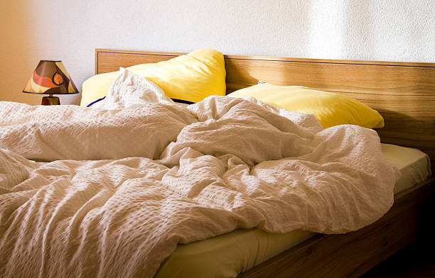 messy,unmade bed with pillows and duvet
