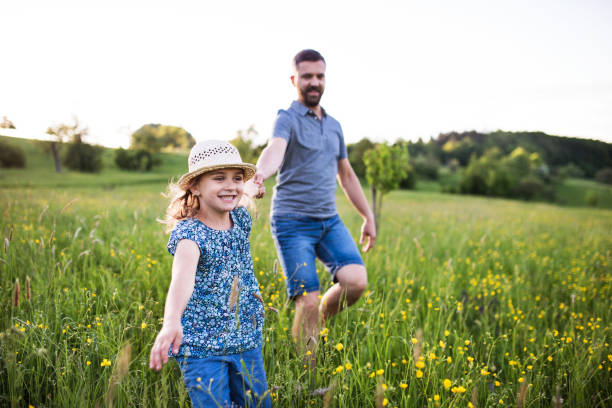istock Father with a small daughter running in spring nature. 979217490