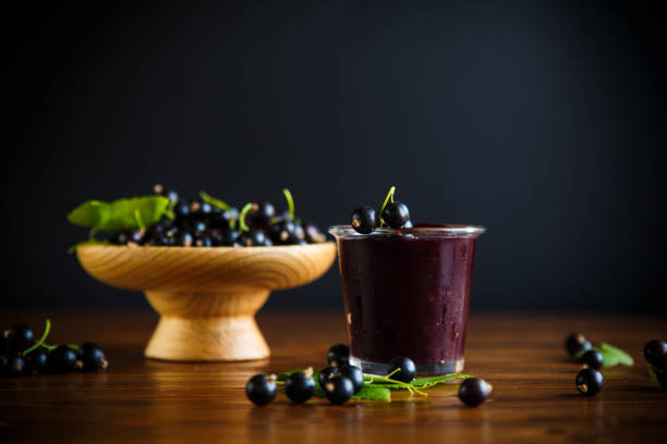 sweet jam of black currant berries on a wooden table