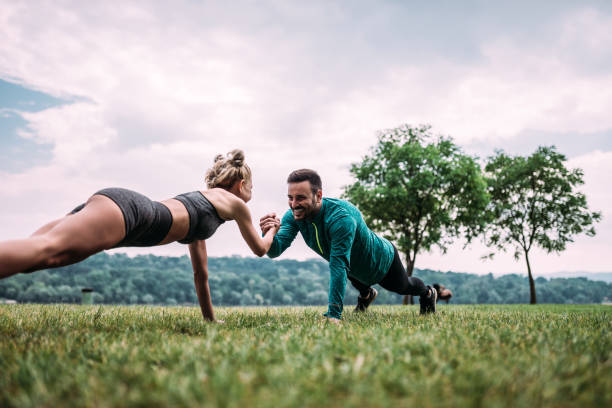 istock Couple standing in a plank position holding each other hand. 979224684