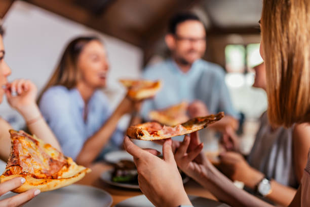 istock Eating pizza with friends. Close-up. 979224980