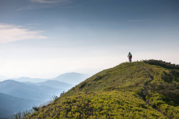 istock Woman rides bicycle up in the mountains 979236180