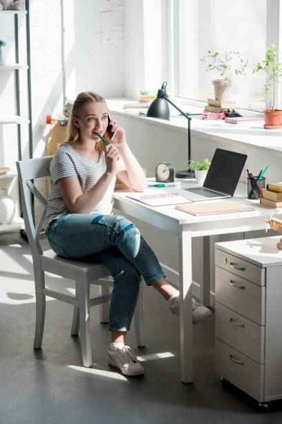 istock teen student girl talking by phone while doing homework 979237926