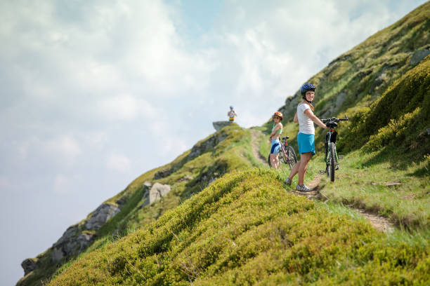 istock Biker pushes bicycle up in the mountains 979246772