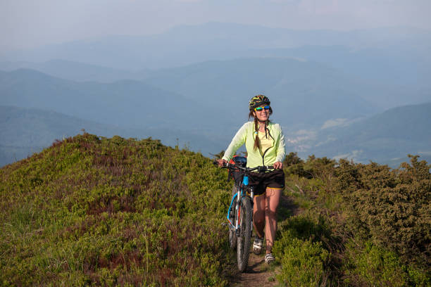 istock Biker pushes bicycle up in the mountains 979246952