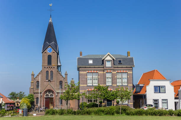церковь мартинуса и старые дома в oudeschild на острове тексель, нидерланды - oudeschild стоковые фото и изображения