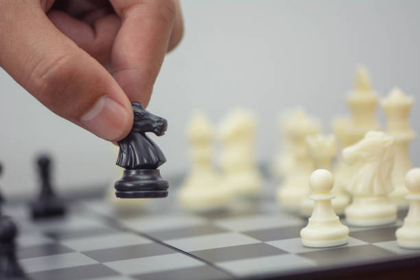 istock hand making move in a chess game, moving the pawn one field forward. Selective focus. 979253168