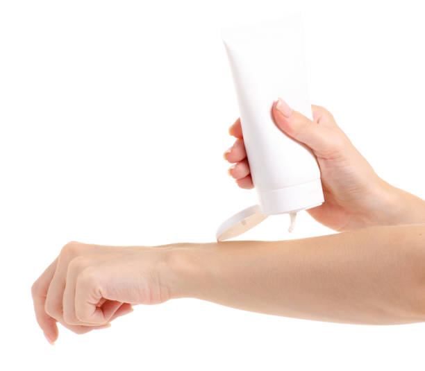 istock White bottle of body cream in hand 979258078