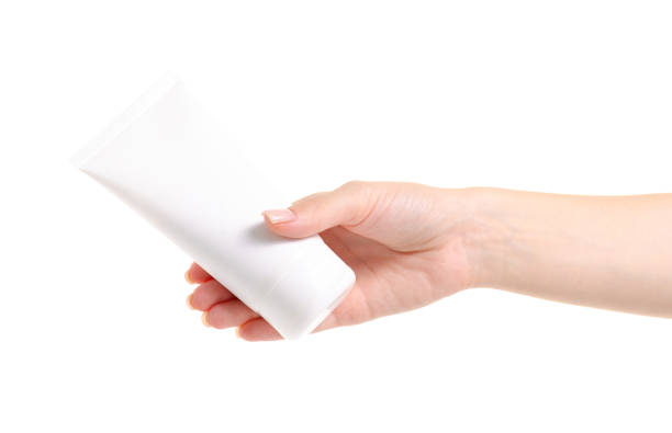 istock White bottle of body cream in hand 979258138
