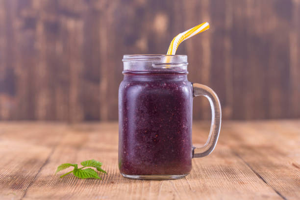 gesunde ernährung, ernährung, diäten und vegetarische konzept - smoothie von mulberry in becher, hautnah. frische mulberry und saft auf holztisch - breakfast close up vegetarian food nature stock-fotos und bilder