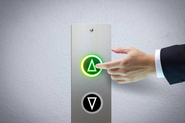 Next level up Hand of a man pressing the elevator button for next levels up in concept of more advance to a success. hand elevator stock pictures, royalty-free photos & images