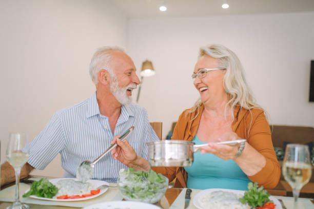 istock Happy couple looking at each other while serving food 979269042