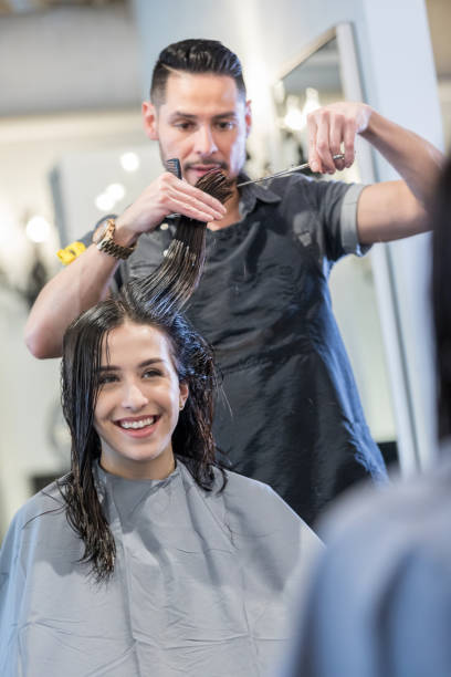 istock Confident hair stylist cuts woman's hair 979269564