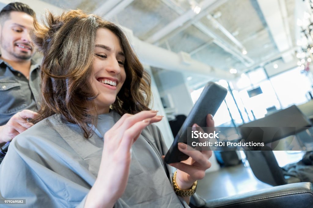 Young Woman Uses Smart Phone In Hair Salon Stock Photo - Download Image Now  - Hair Salon, Text Messaging, Beauty Spa - iStock