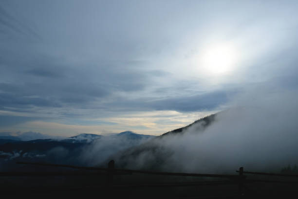 istock Mountain range with visible silhouettes through the morning colorful fog. 979269632
