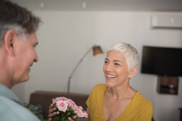 istock Woman holding roses looking at her husband and smiling 979270652