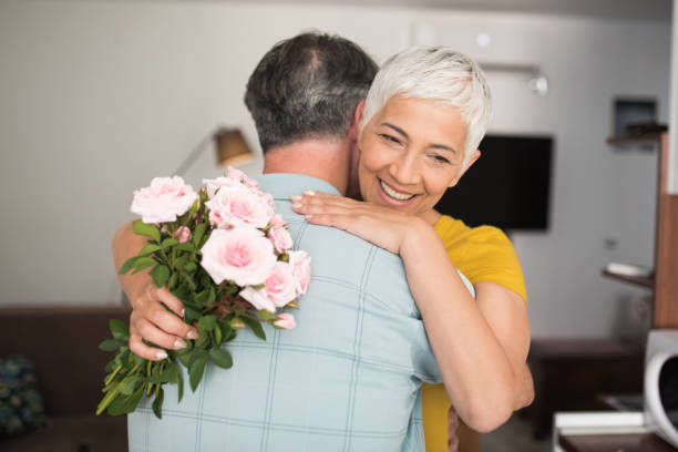 istock Happy woman holding roses and hugging a man 979270814