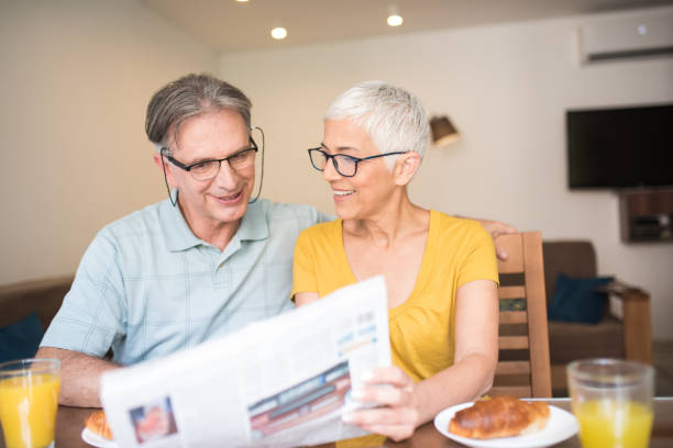 istock Happy couple looking at newspapers 979270872