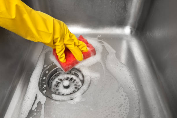 istock hands in gloves cleaning kitchen sink 979273970