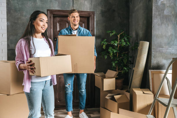 istock beautiful young couple with boxes moving into new home 979290536