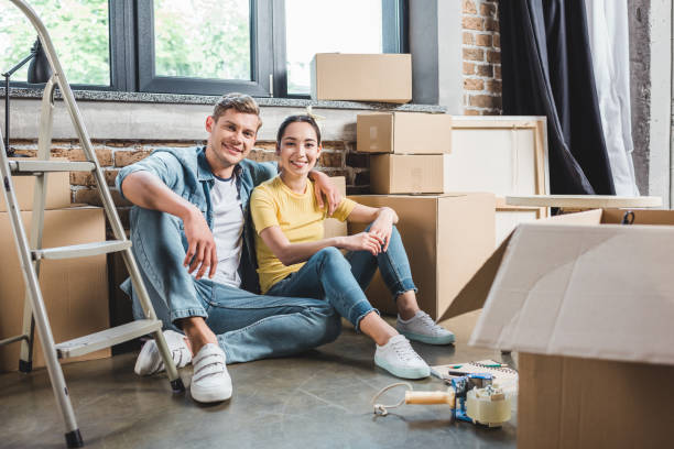 istock smiling young couple sitting on floor together while moving into new home 979292328