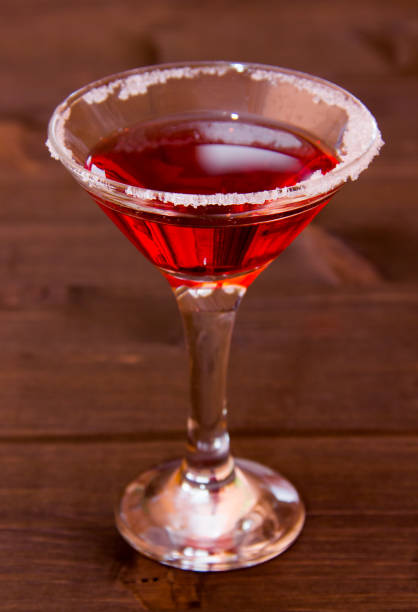 istock Red cocktail with decorated sugar on a wooden table seen close up 979296778