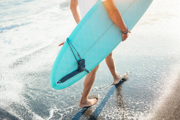 istock Surfer in white t-shirt walking with surf board 979297958