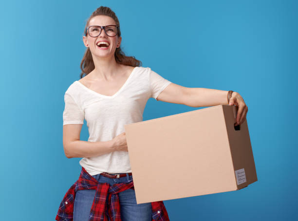 istock hipster with cardboard box looking up at copy space on blue 979305408
