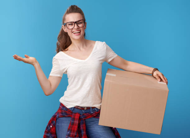 istock woman with a cardboard box presenting something on empty palm 979305500