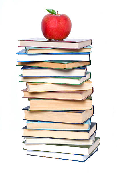 Books tower with apple isolated on white stock photo