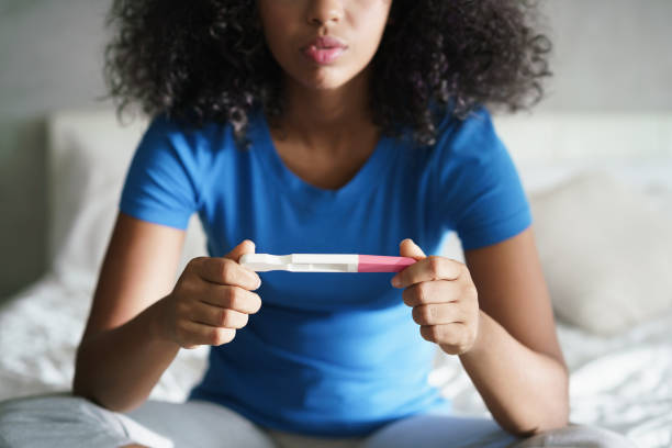 Sad Young Woman With Pregnancy Test At Home stock photo