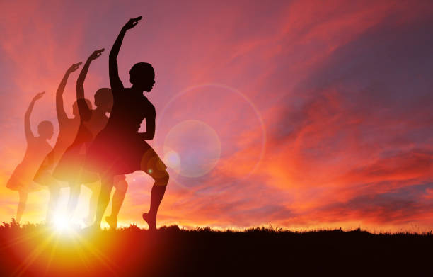 istock Silhouette Girls Dancing at Golden Sunrise 979330932