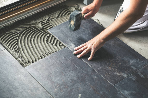 worker placing ceramic floor tiles - azulejo imagens e fotografias de stock