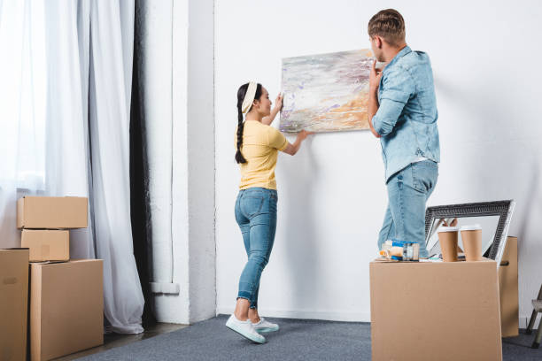 istock young couple handing abstract picture on wall while moving into new home 979348746