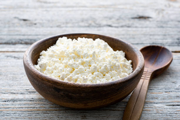 Ricotta cheese, cottage cheese farmers cheese, curd or tvorog in a wooden bowl Ricotta cheese, cottage cheese farmers cheese, curd or tvorog in a wooden bowl. Closeup view, selective focus curd cheese stock pictures, royalty-free photos & images