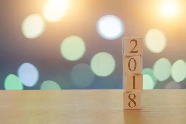 Year 2018 on wooden cubes on a beautiful bokeh background with lights