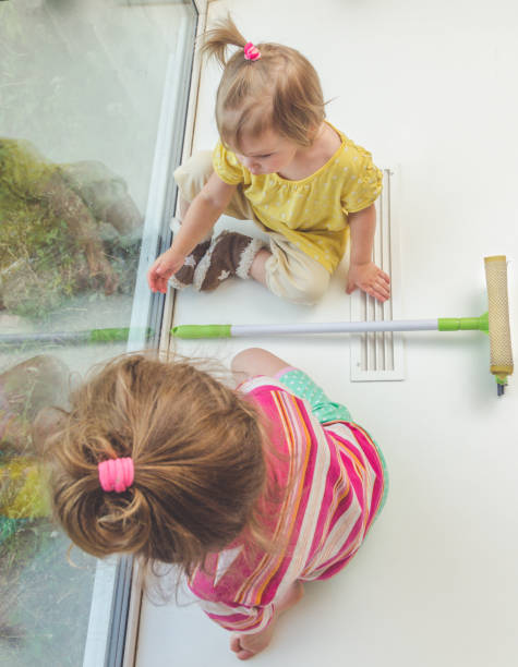 istock child on the windowsill washes the window 979357486