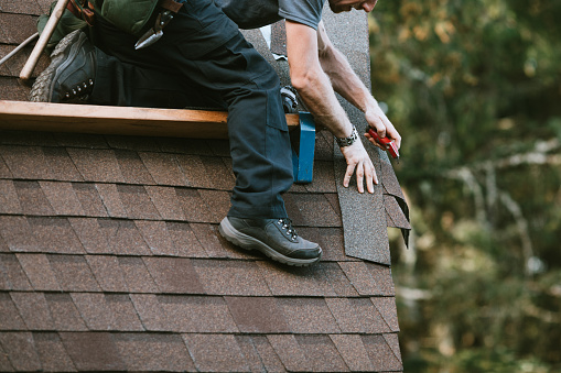 A roofer and crew work on putting in new roofing shingles.  Small local business serving local families in Washington State.