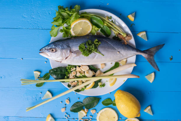 istock Fish food with ingredient spices on blue table 979369706