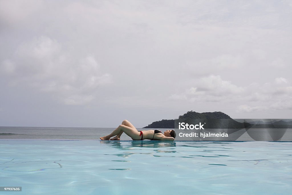 enjoying the paradise enjoying the paradise in the edge of a pool Adult Stock Photo