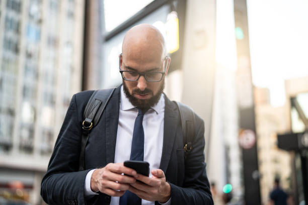 uomo d'affari che usa il cellulare in città - business blurred motion text messaging defocused foto e immagini stock