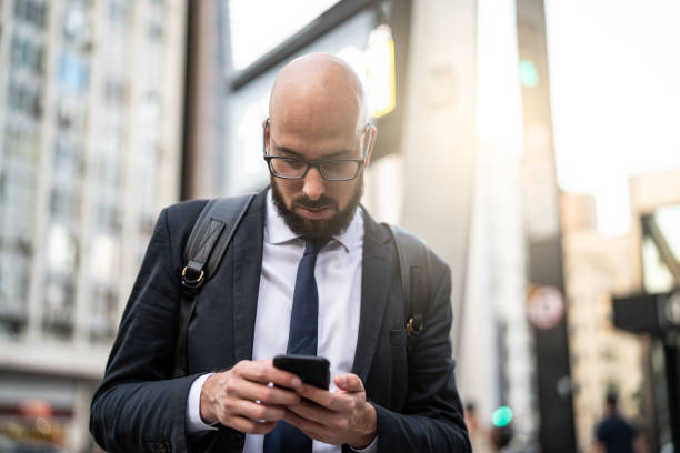 businessman using mobile at city - business blurred motion text messaging defocused imagens e fotografias de stock