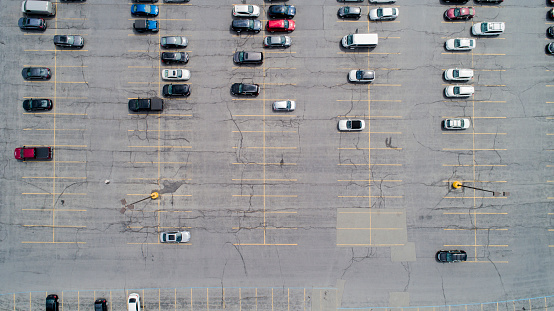 Aerial directly above view of the parking lot with the crackled asphalt and parking markup lot next to a shopping mall in Pennsylvania, USA