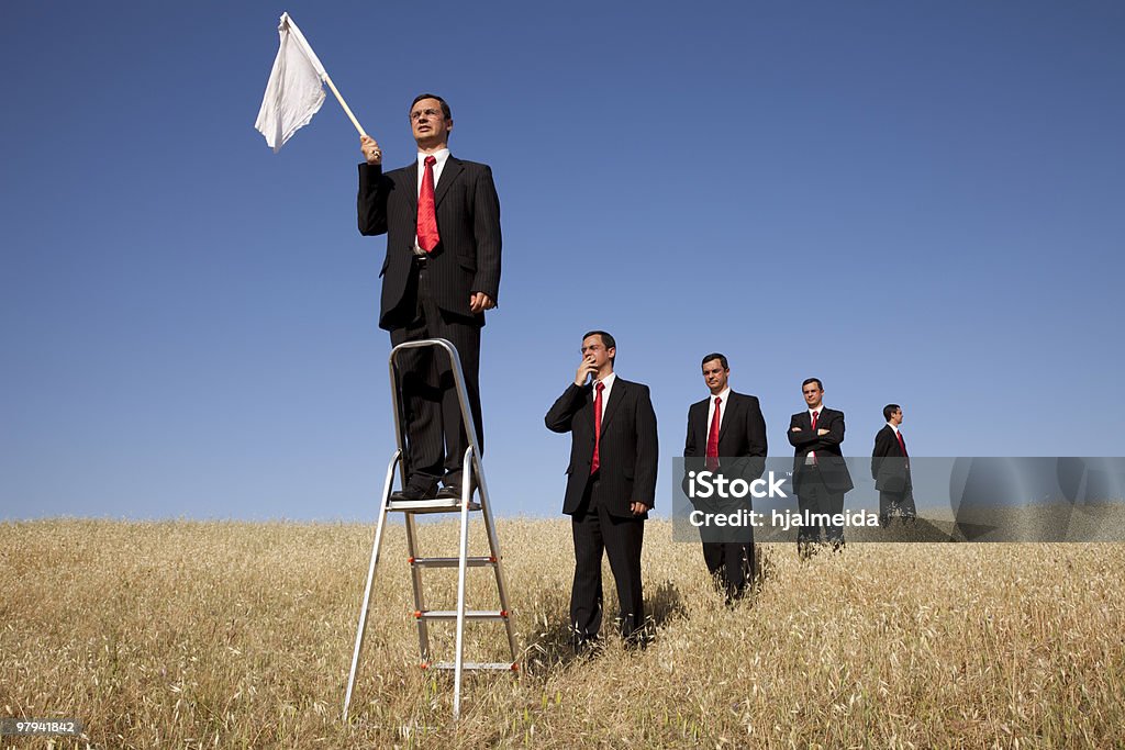 Get in line to fail a group of businessman in the field getting in line for there time to surrendering Surrendering Stock Photo