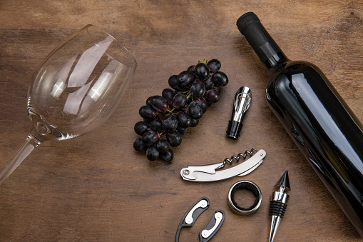 Wine tasting concept. A vintage corkscrew and a cork, overhead shot on a dark background