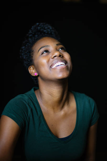 istock Smiling Woman Looking Up On Black Background 979434142