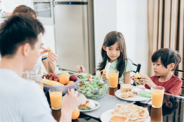 istock Mother, father and two children eating together 979442516
