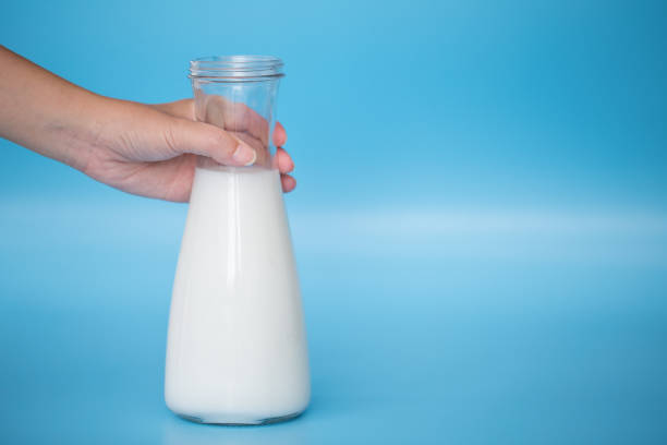 istock Hand holding a glass of milk. 979442702