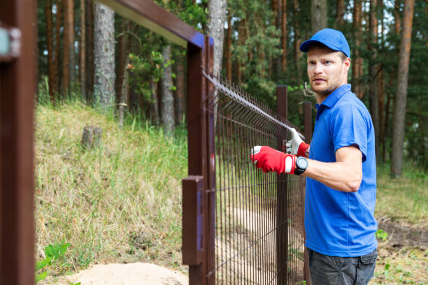 istock man installing brown metal fence 979444576