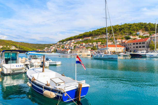 Fishing boats mooring in picturesque Pucisca port PUCISCA PORT, BRAC ISLAND - SEP 7, 2017: Fishing boats mooring in picturesque Pucisca port, Brac island, Croatia old catholic church on island brac croatia stock pictures, royalty-free photos & images